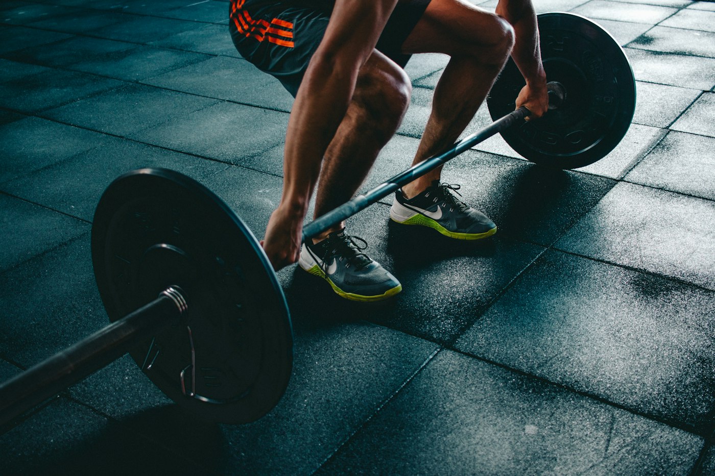 Deportista levantando una barra con discos en una sala de entrenamiento